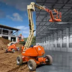 JLG H340AJ Hybrid boom lifts at outdoor building site.