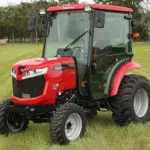 Mahindra 1635 Compact Utility Tractor with cab parked in open grass field.