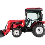 Side view of Mahindra 2638 HST compact utility tractor with cab and bucket loader attachment.