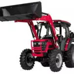 Mahindra 6075 utility tractor with cab and raised bucket attachment.