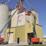 Skyjack SJ66 T+ telescopic boom lift raising an operator for facility maintenance.