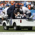 Taylor-Dunn Bigfoot Burden Carrier carrying DeVante Bausby from Denver Broncos off the football field.