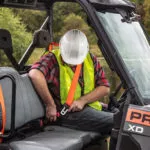 Polaris Commercial PRO XD Full-Size Diesel Utility Vehicle operator buckling up.