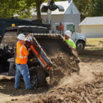 Polaris Commercial Pro XD Full-Size Gas utility vehicle dumping bed full of dirt.