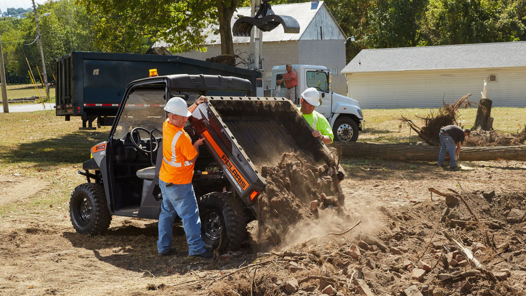 Polaris Commercial Pro XD Full-Size Gas utility vehicle dumping bed full of dirt.