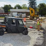 Polaris Commercial PRO XD Full-Size Diesel Crew UTV side view with doors on gravel work site.