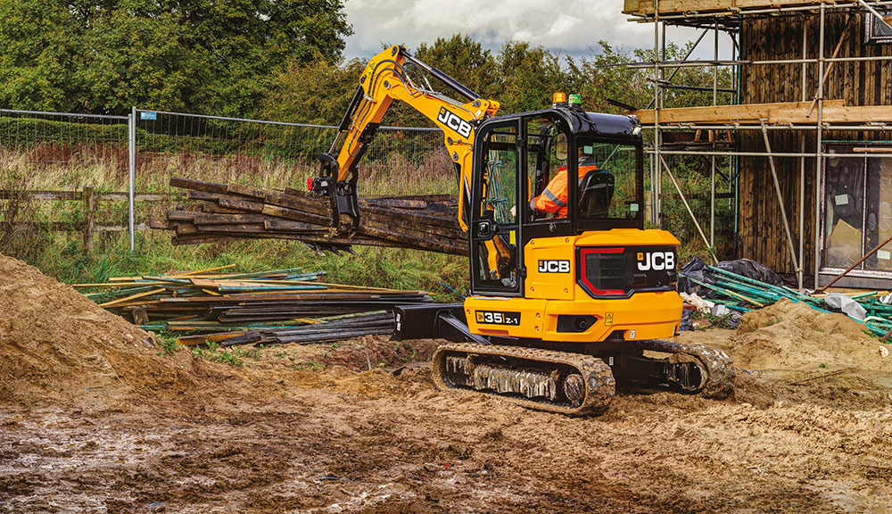 JCB 35z-1 compact excavator carrying materials at construction site.