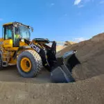 JCB 437 Wheel Loader construction and agriculture truck scooping stones on construction site.