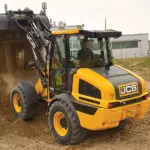 JCB 409 Wheel Loader construction and agriculture truck dumping dirt.