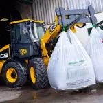 JCB TM-220 articulated telescopic handler carrying agriculture materials.