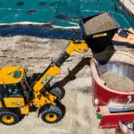 JCB TM-220 articulated telescopic handler dumping material.