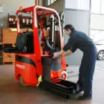 Technician repairing Mariotti MYCROS AC RWD 10C Forklift in shop.
