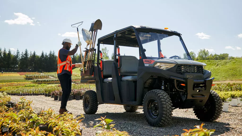 tools being loaded onto Pro XD Mid-Size Gas Crew Utility Vehicle by Polaris Commercial.