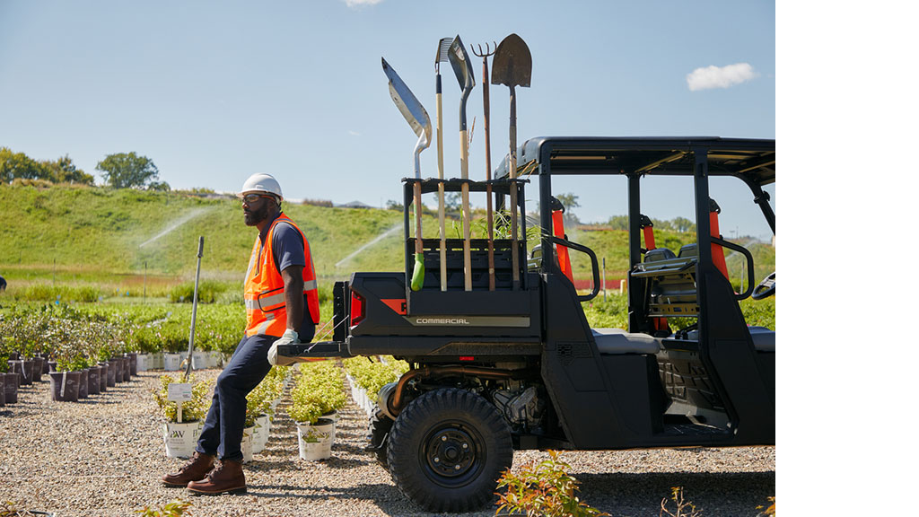 Pro XD Mid-Size Gas Crew Utility Vehicle by Polaris Commercial with man sitting on bed.