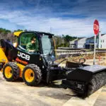 JCB 215 Skid Steer sweeping road.