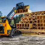 JCB 2TS-7T skid steer loader lifting building materials.