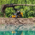 JCB 300T Compact Track Loader lifting tree log.