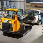 JCB 3TS-8T compact track loader placing pallet of materials in the bed of a pickup truck.