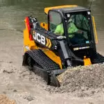 JCB 3TS-8T compact track loader scooping wet mud.