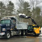 JCB 3TS-8T teleskid dumping snow into dump truck.