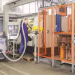 Operator cleaning warehouse work area with Nilfisk S2 vacuum.