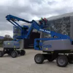 Genie Z-45 FE Boom Lifts on gravel at an outdoor worksite.