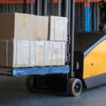TASK Forklifts Cobra legless stacker transporting pallet of boxes.