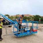 Genie S-60 HF Telescopic Boom Lift on gravel terrain.