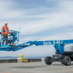 Workers in bucket, driving Genie S-60 J telescopic boom lift.