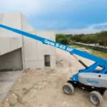 Genie S-65 HF telescopic boom lift raising workers to the top of a building.
