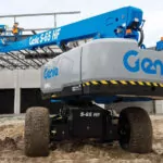 Genie S-65 HF boom lift raising workers to work on building.