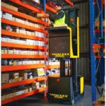 TASK Sidewinder task support vehicle lifting operator up to place a box on a high warehouse shelf.