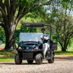 Cushman Hauler 800 utility vehicle driving on gravel path.