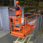 Worker elevated on JLG R3246 electric scissor lift.