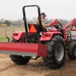 Mahindra 4550 4WD Tractor with bucket attachment driving in farm field.