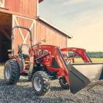Mahindra MAX 26 XLT HST tractor at a farm with bucket loader.