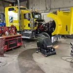 Kodiak K19 cylindrical walk-behind floor scrubber in automotive garage.