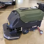 Kodiak K25 walk-behind scrubber with disk deck in garage.