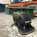 Kodiak K25 walk-behind scrubber with disk deck in warehouse facility.