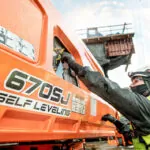 Worker modifying JLG 670SJ boom lift operator controls.