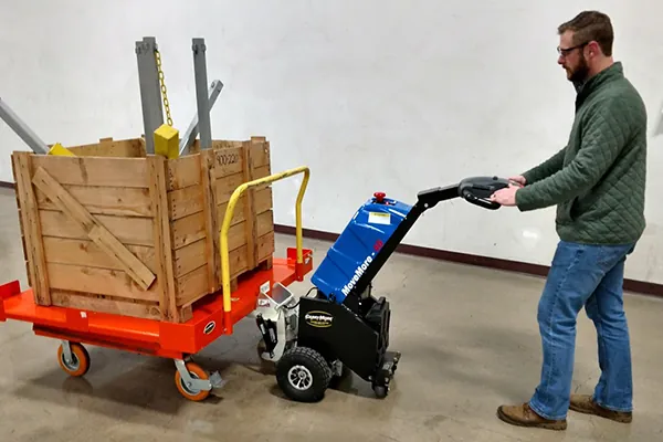 Man pulling bin cart with a walkie tugger.