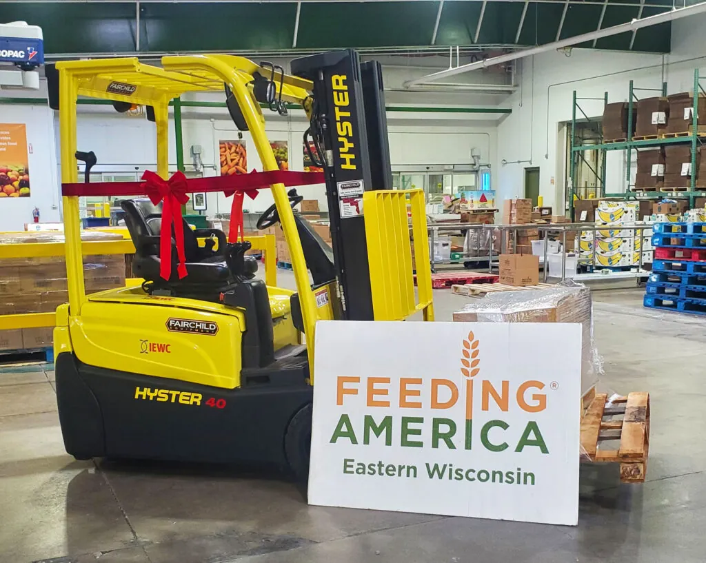 Hyster forklift with ribbon and Feeding America Eastern Wisconsin sign.