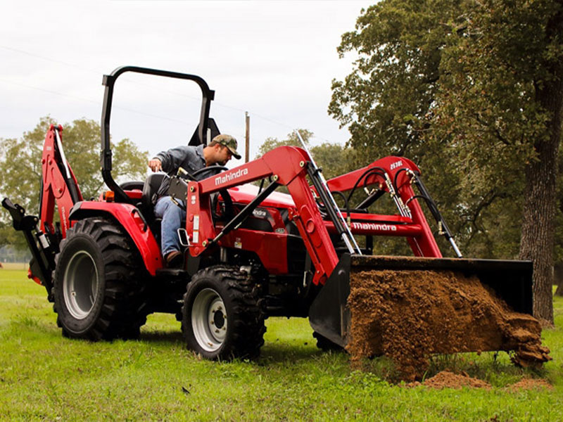 Mahindra 2638 HST Tractor in field with bucket attachment.