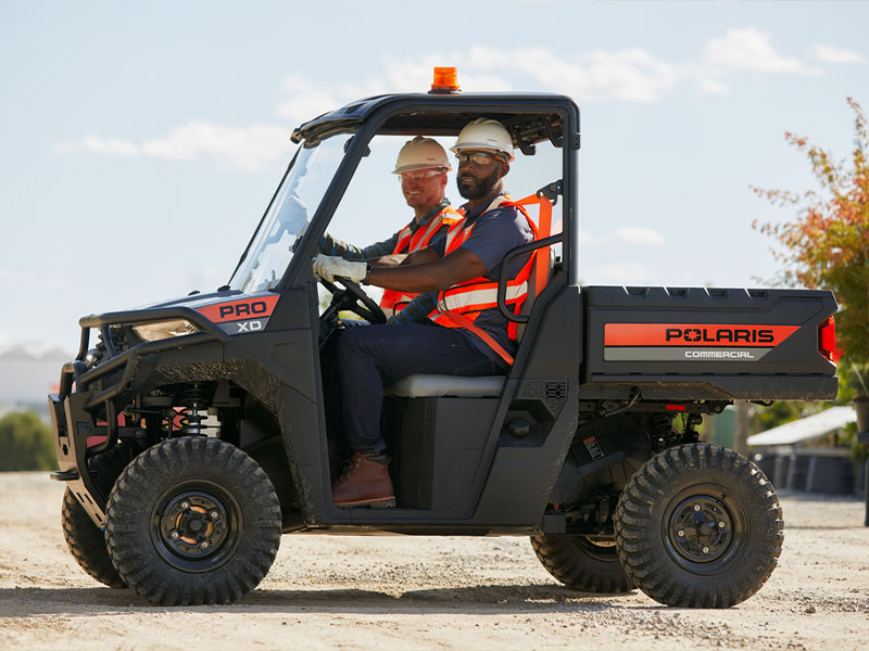 Polaris Pro XD Mid-Size Gas utility vehicle on dirt road.
