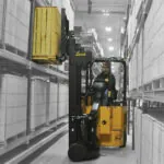 Bendi B30AC lift truck grabbing pallet of materials off warehouse shelf.