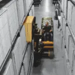 Drexel SL50AC forklift raising pallet onto warehouse shelving.