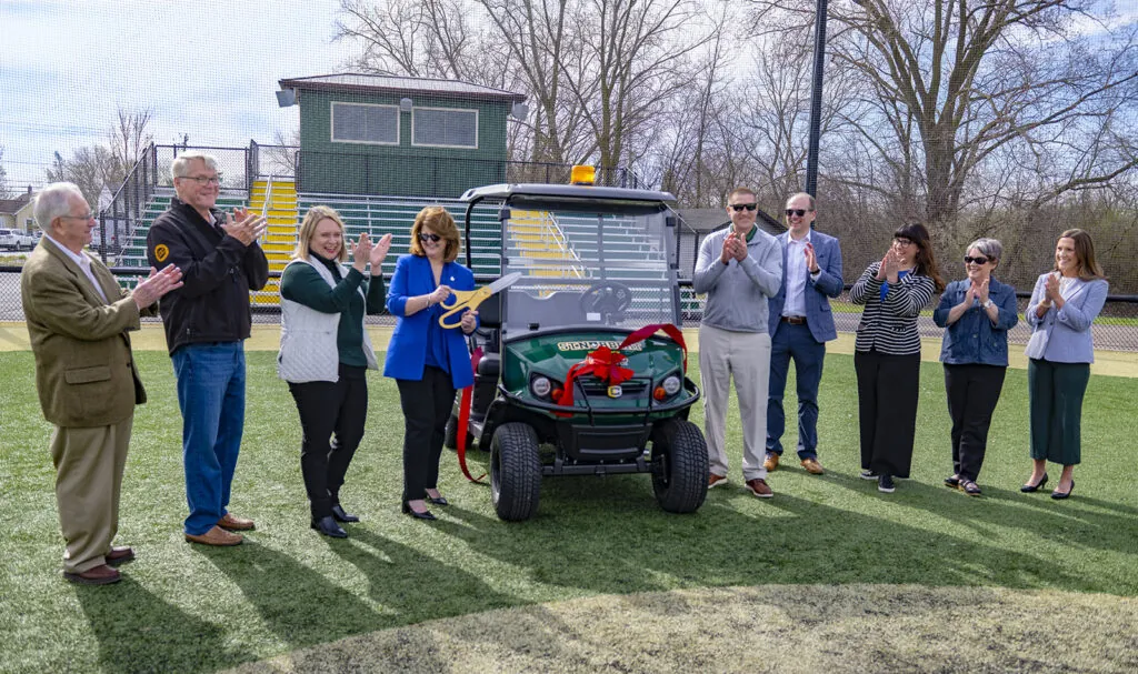 Dr. Mike Marsden, Gary Fairchild, Mandy Netzel, Dr. Laurie Joyner, Chad Fairchild, Cam Fuller, Amy Chandik Kundinger, Chris Betcher, and Natalie Jaroch with donated Cushman vehicle.