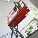 Skyjack SJ3219 Micro Scissor Lift raised to ceiling.