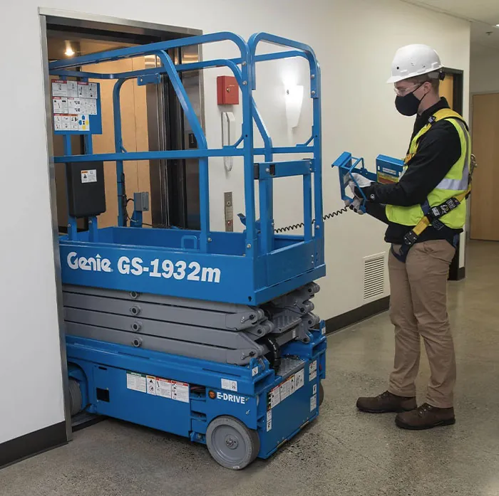 Genie GS1932m scissor lift driving through doorway.