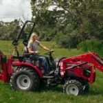 Mahindra 2100 Series Compact Tractor with bucket and backhoe loader attachments.